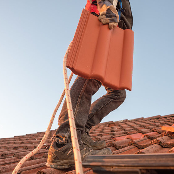 A Roofer Carrying a Tile.