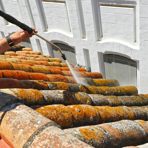 Hydro pressure washer washes terracotta clay tiles.