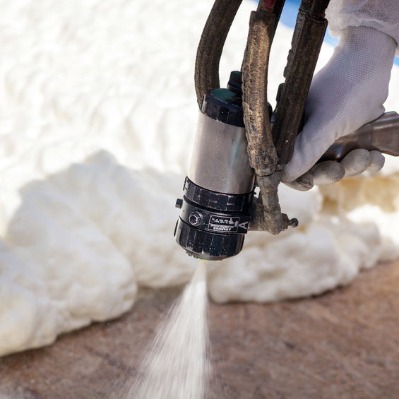 A Roofer Sprays Foam Over a Roof.