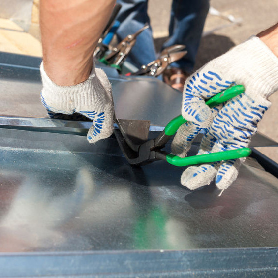 A Roofer Installing a Metal Panel.