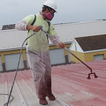 A Roofer Applies a Coating