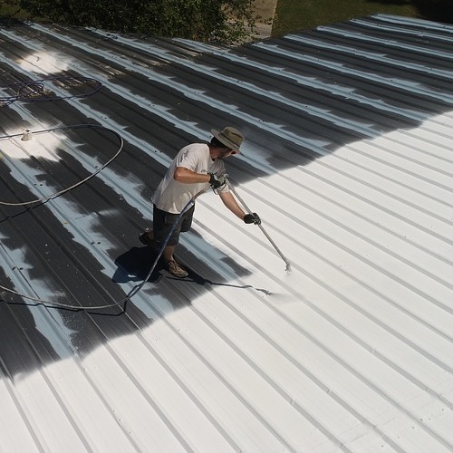 A Roofer Applying a Roof Restoration Coating.