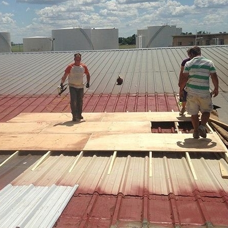 Roofers Work on a Metal Building.