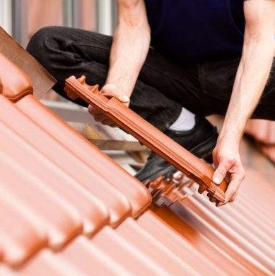 A Roofer Installs Tiles.